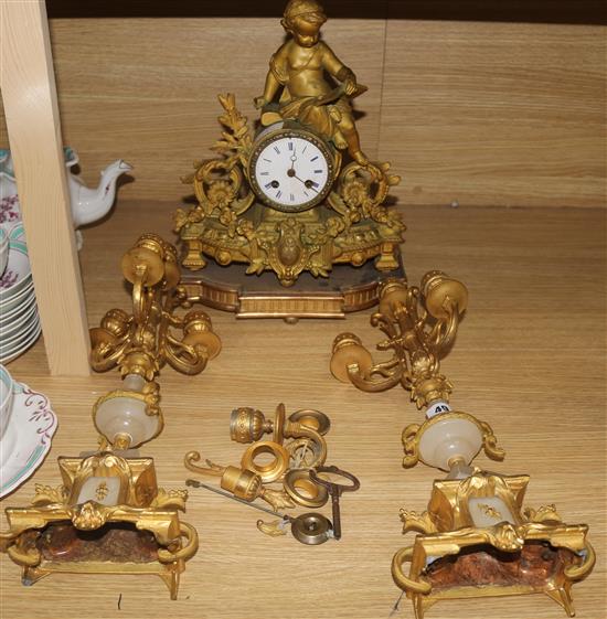 A spelter putti clock and non matching garniture